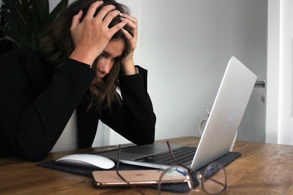 A woman working on a laptop before getting a doctor’s excuse online