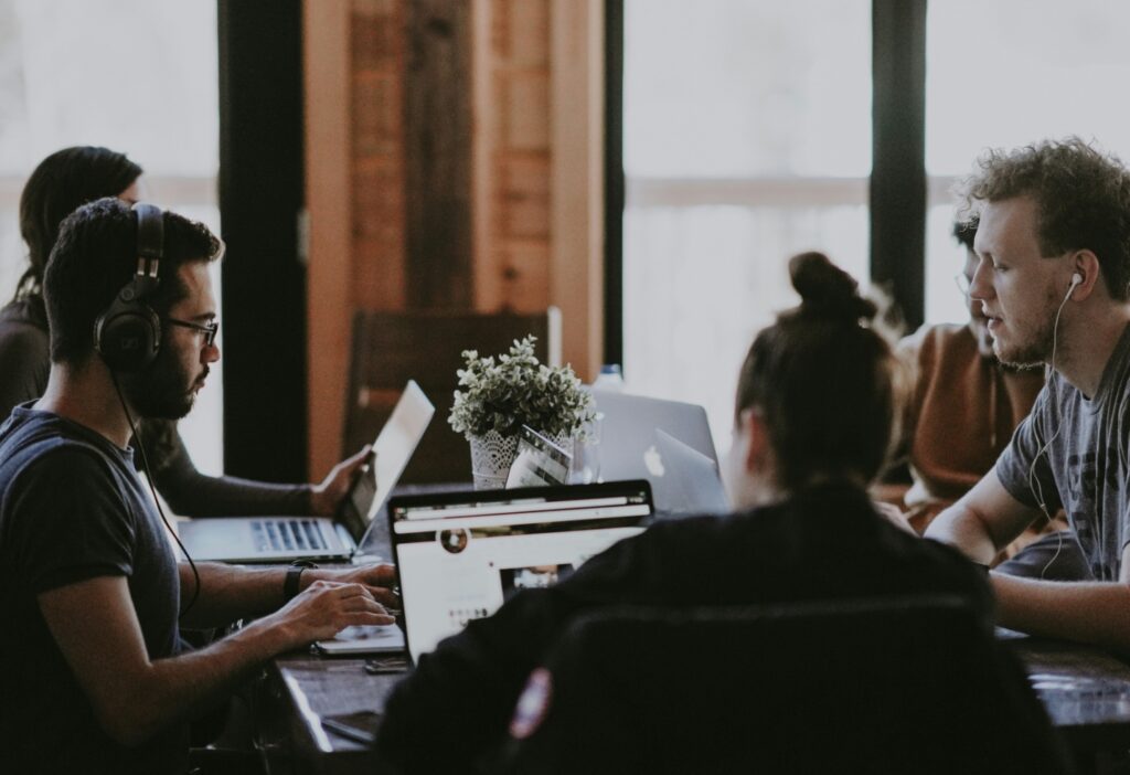 Several people working on their laptops as they sit across the table.