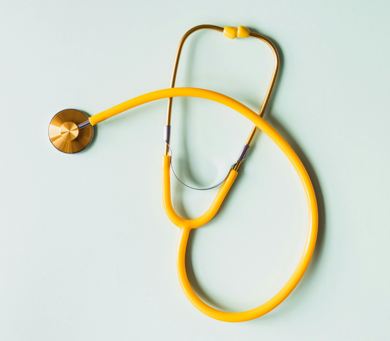 Yellow stethoscope lying on a white surface