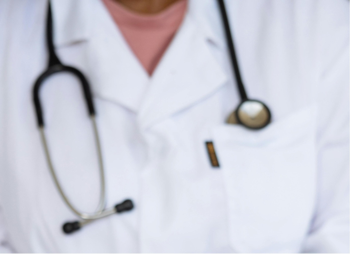 Doctor with a stethoscope around the neck wearing a white coat.