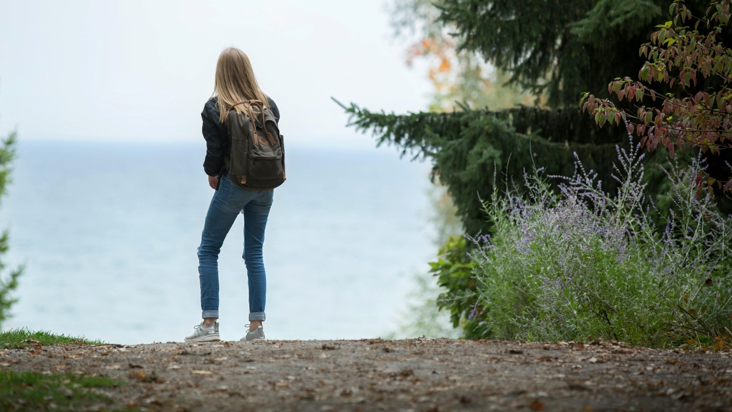 Girl wearing backpack surrounded by nature
