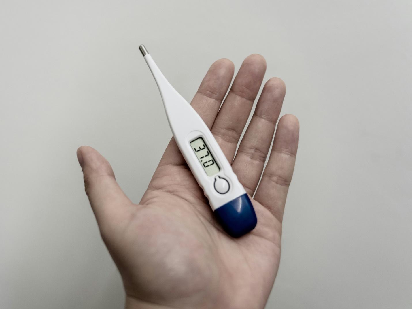 A person holding a thermometer