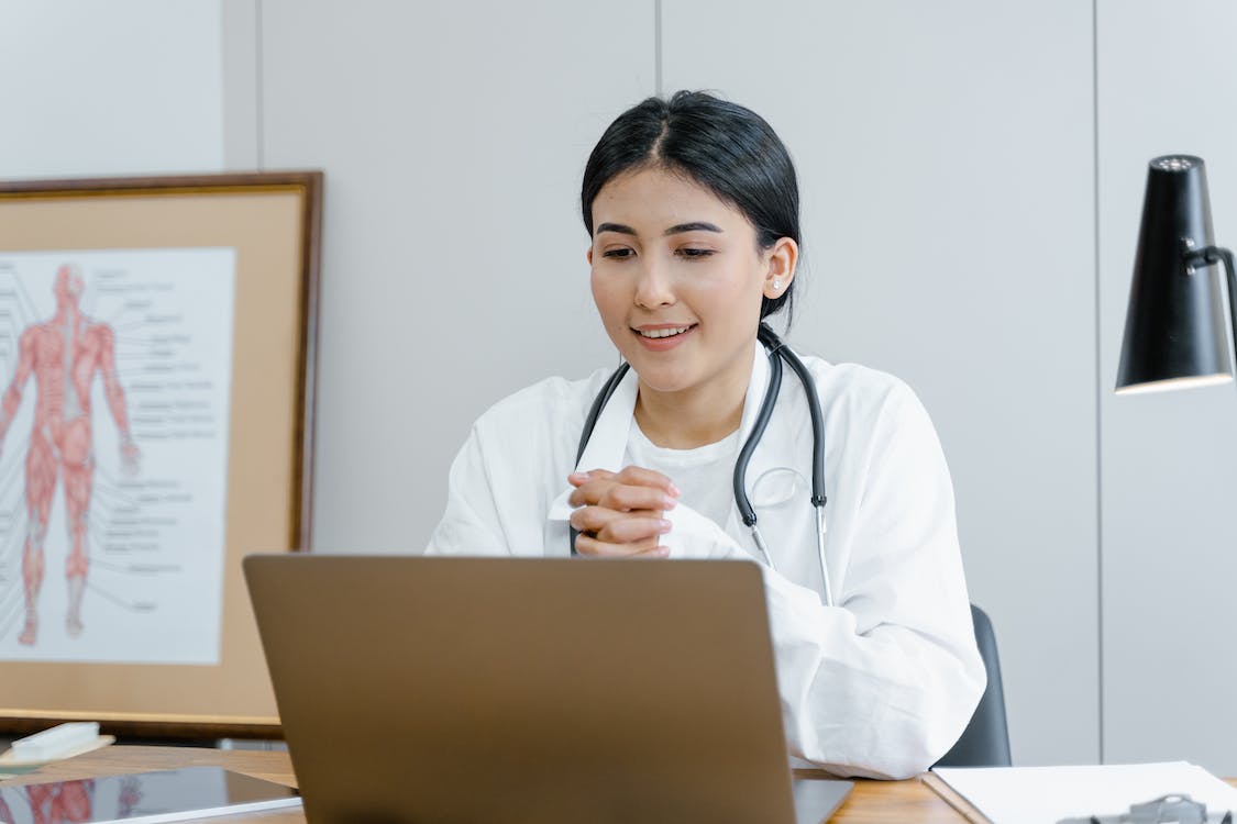 A doctor in front of a laptop