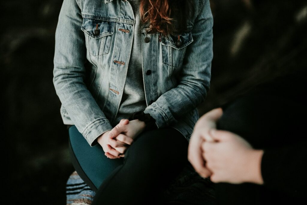 A woman sitting while holding hands