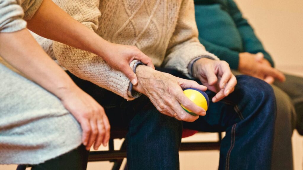 Elderly man sitting with other people