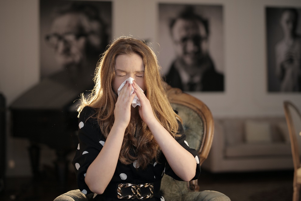 Woman using a tissue with eyes closed 