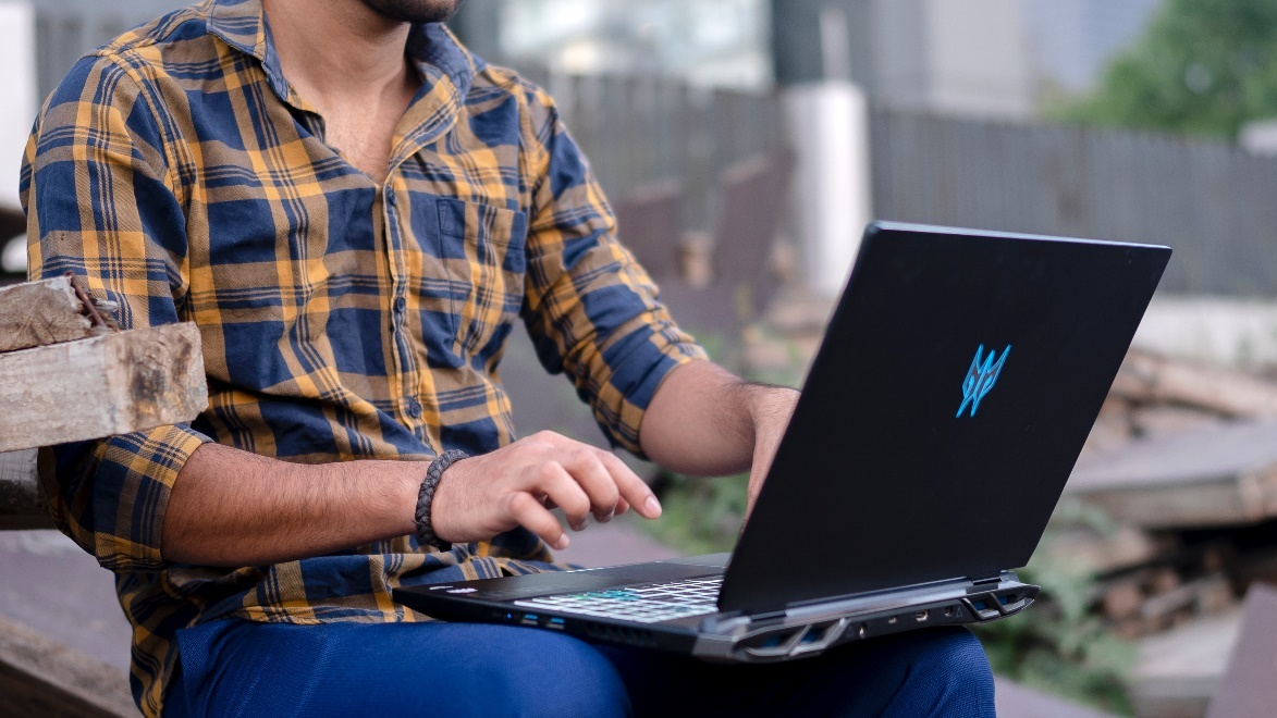 Man typing something on his black laptop