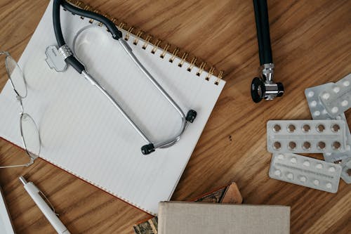 Medical equipment next to a notepad, representing the process of creating online doctor notes.