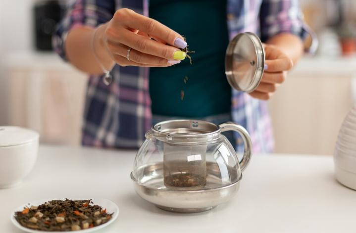 Woman making herbal tea for digestive issues 