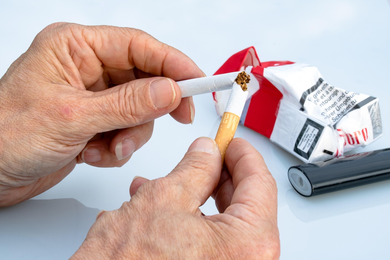 A man breaking a cigarette in half