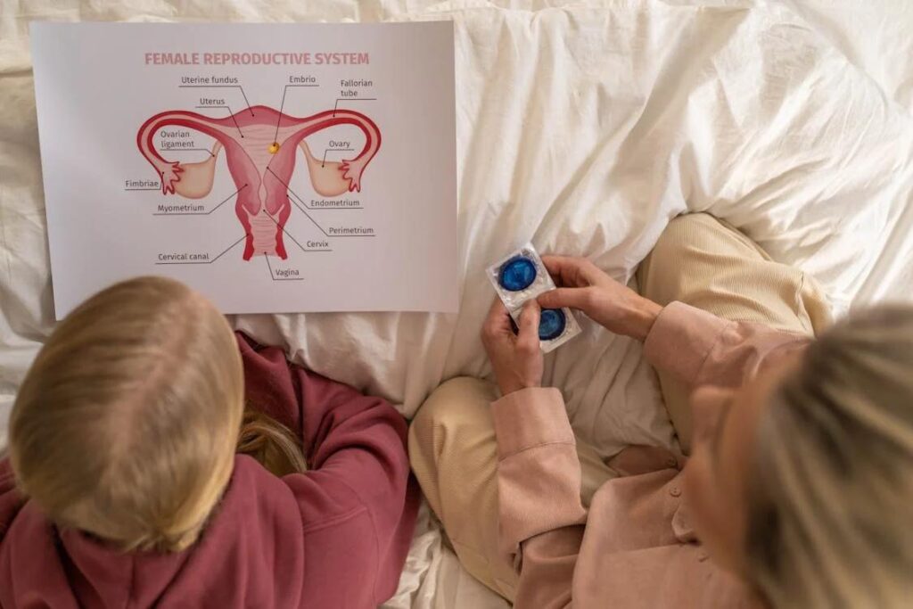 A mother explaining a diagram of female anatomy to her daughter.