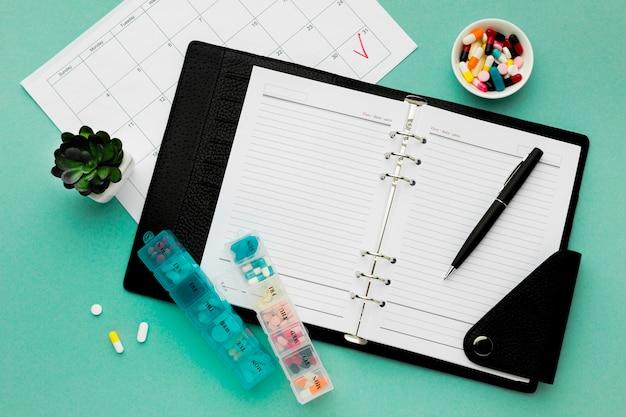 A planner with pills scattered around.