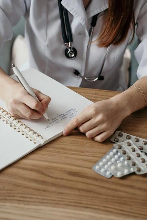 A doctor writing on a notebook.