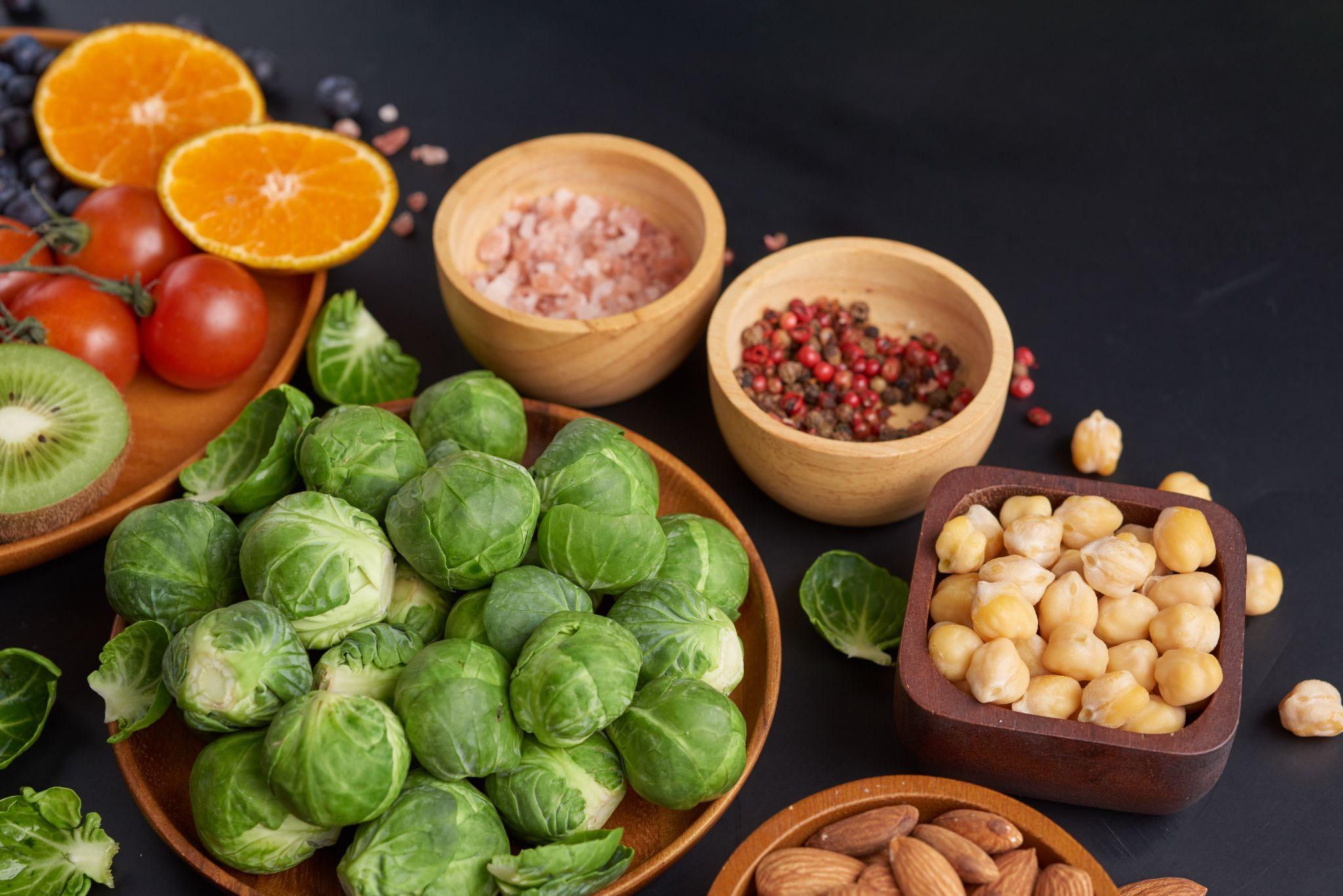 A variety of iron-rich foods, including leafy greens, legumes, and nuts, spread out in bowls.