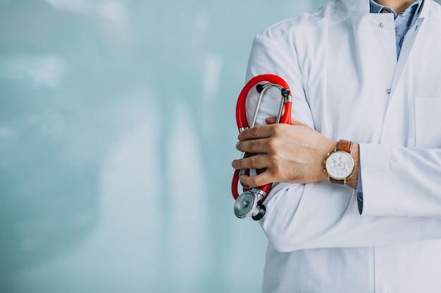 A young male doctor in a medical coat with a stethoscope.