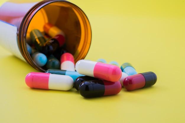 Various medications and pills on a yellow background.