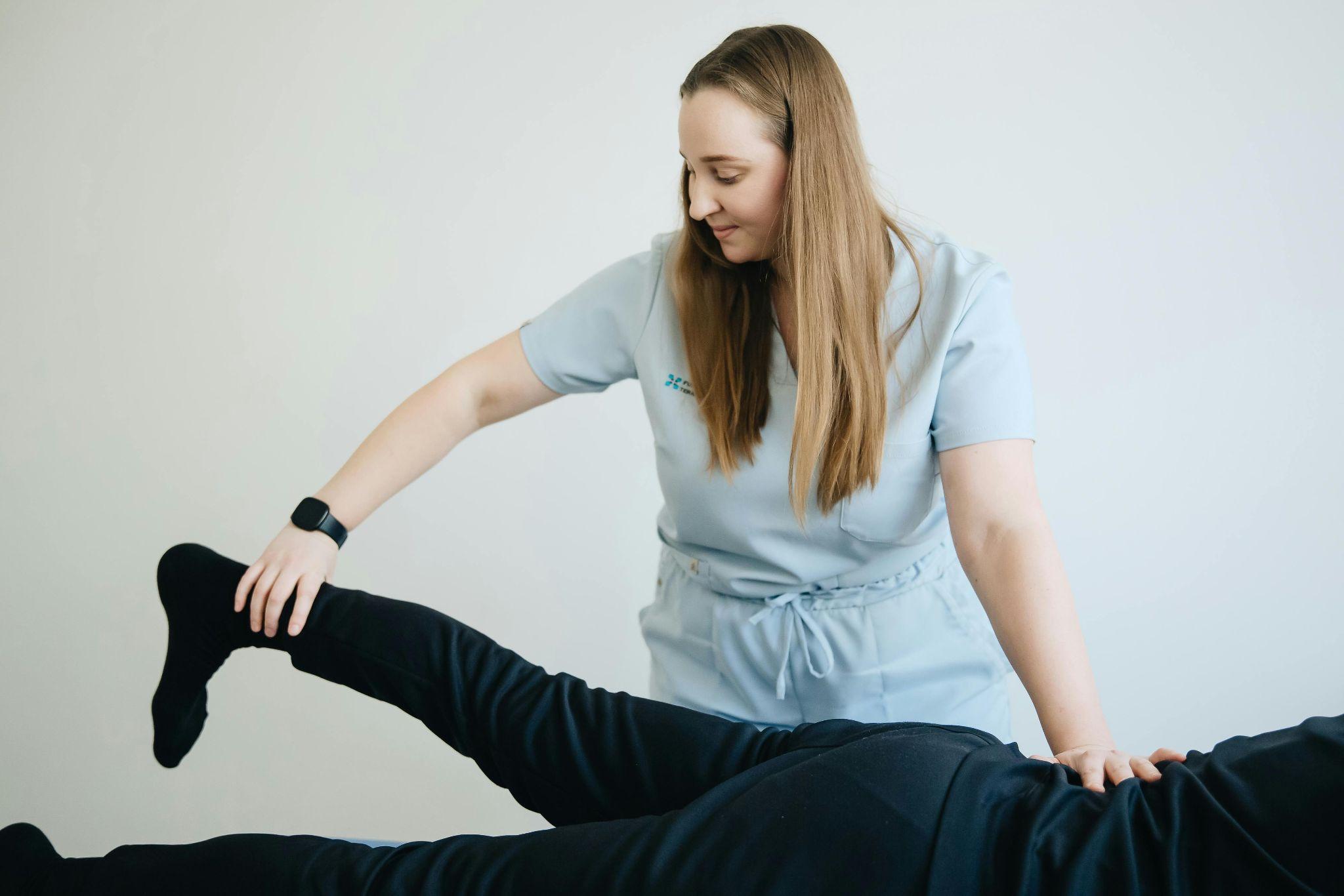 A physical therapist assisting a patient with leg stretches.