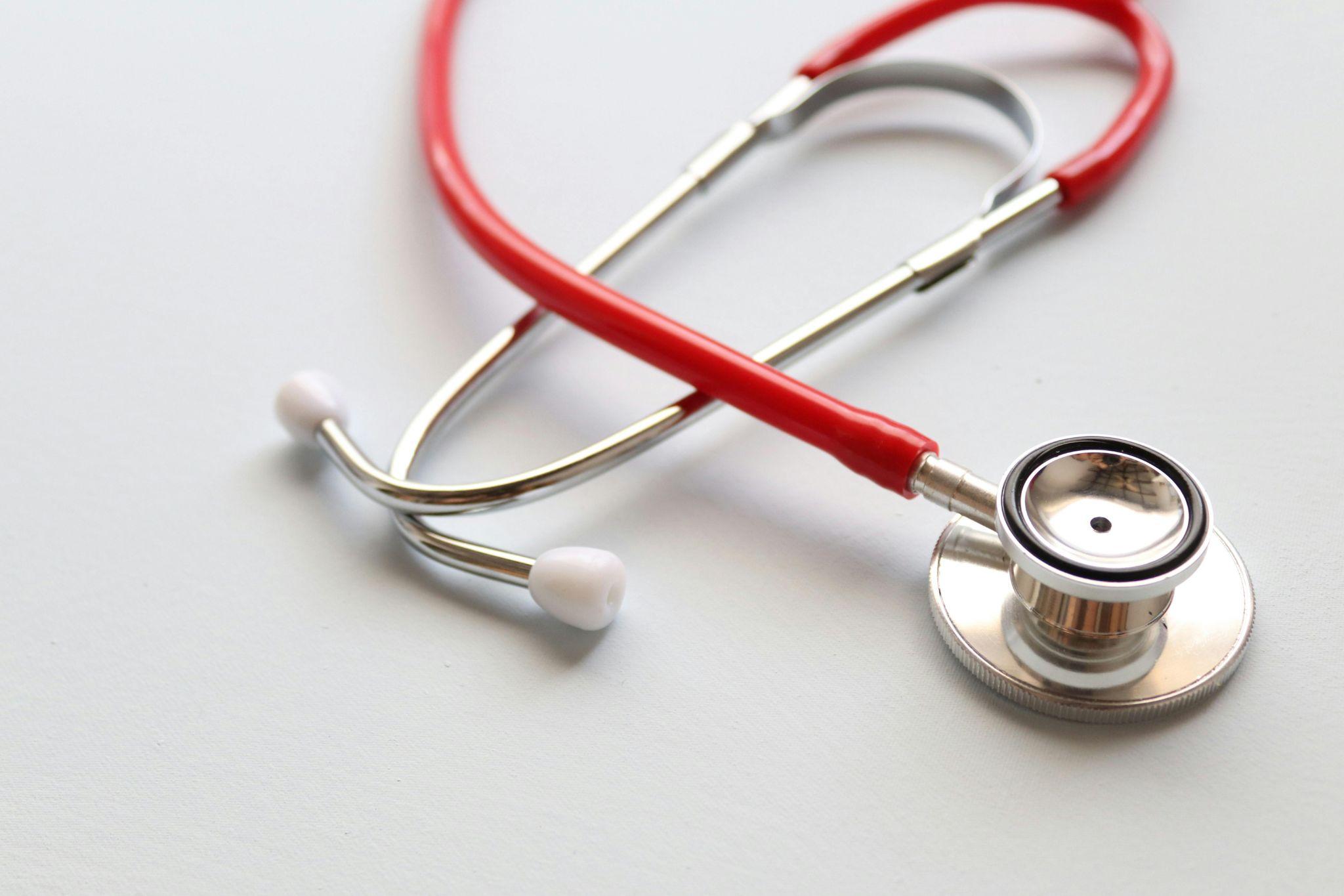 A doctor’s stethoscope is placed on a table.