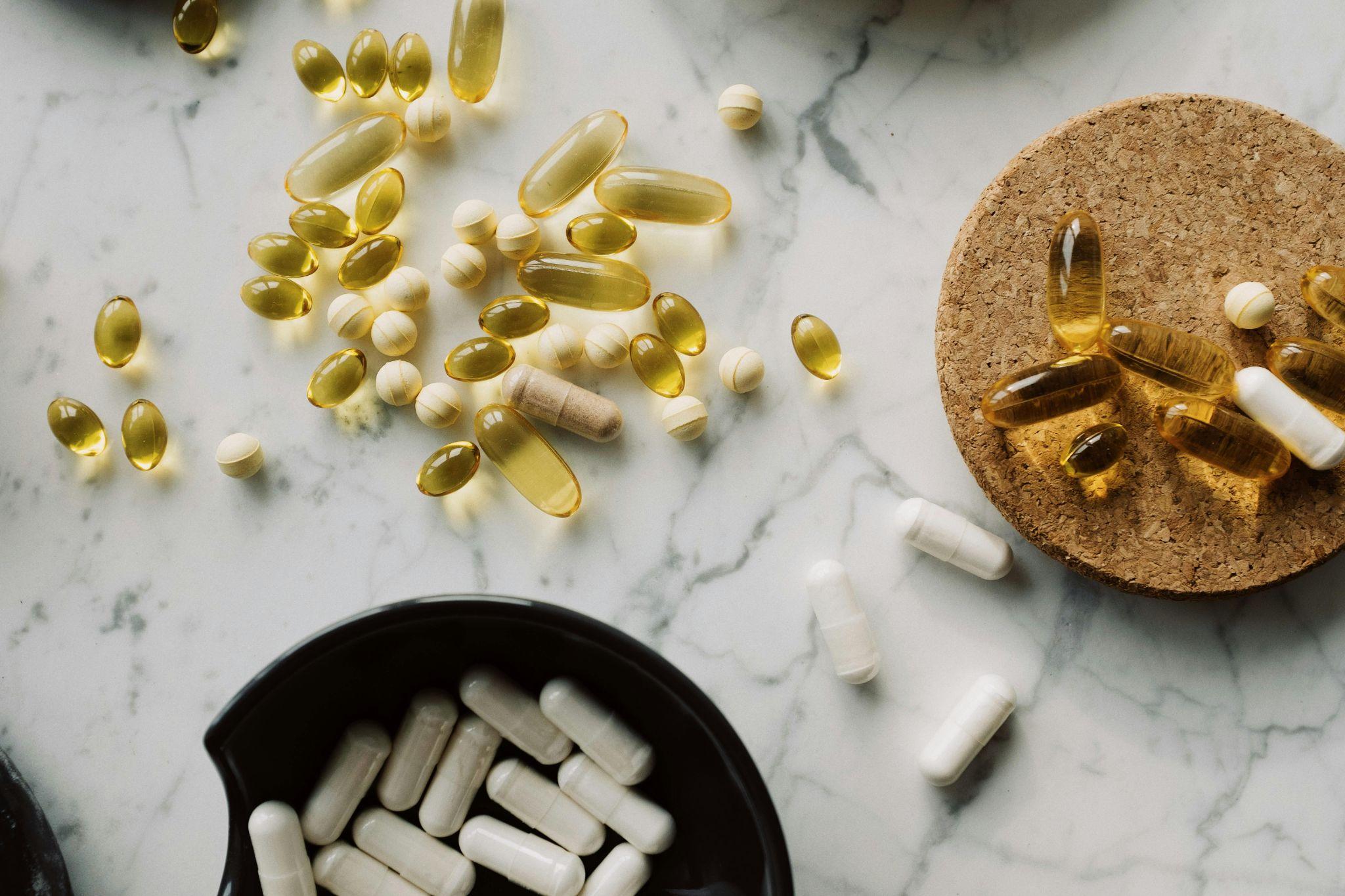 Vitamin supplements spread out on a tabletop.