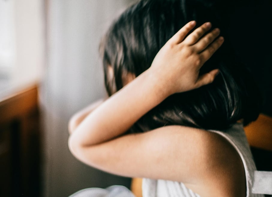 Child covering her ears in pain