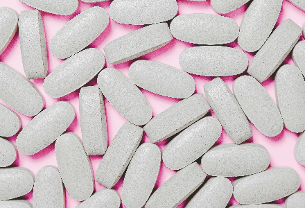 White pills against a pink background