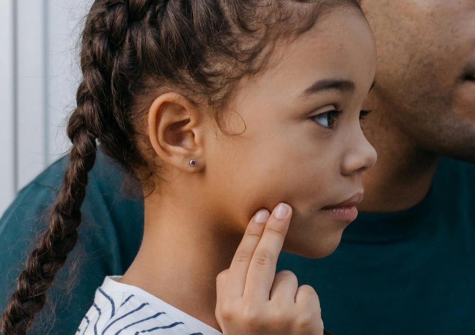 Child touching her jaw tenderly