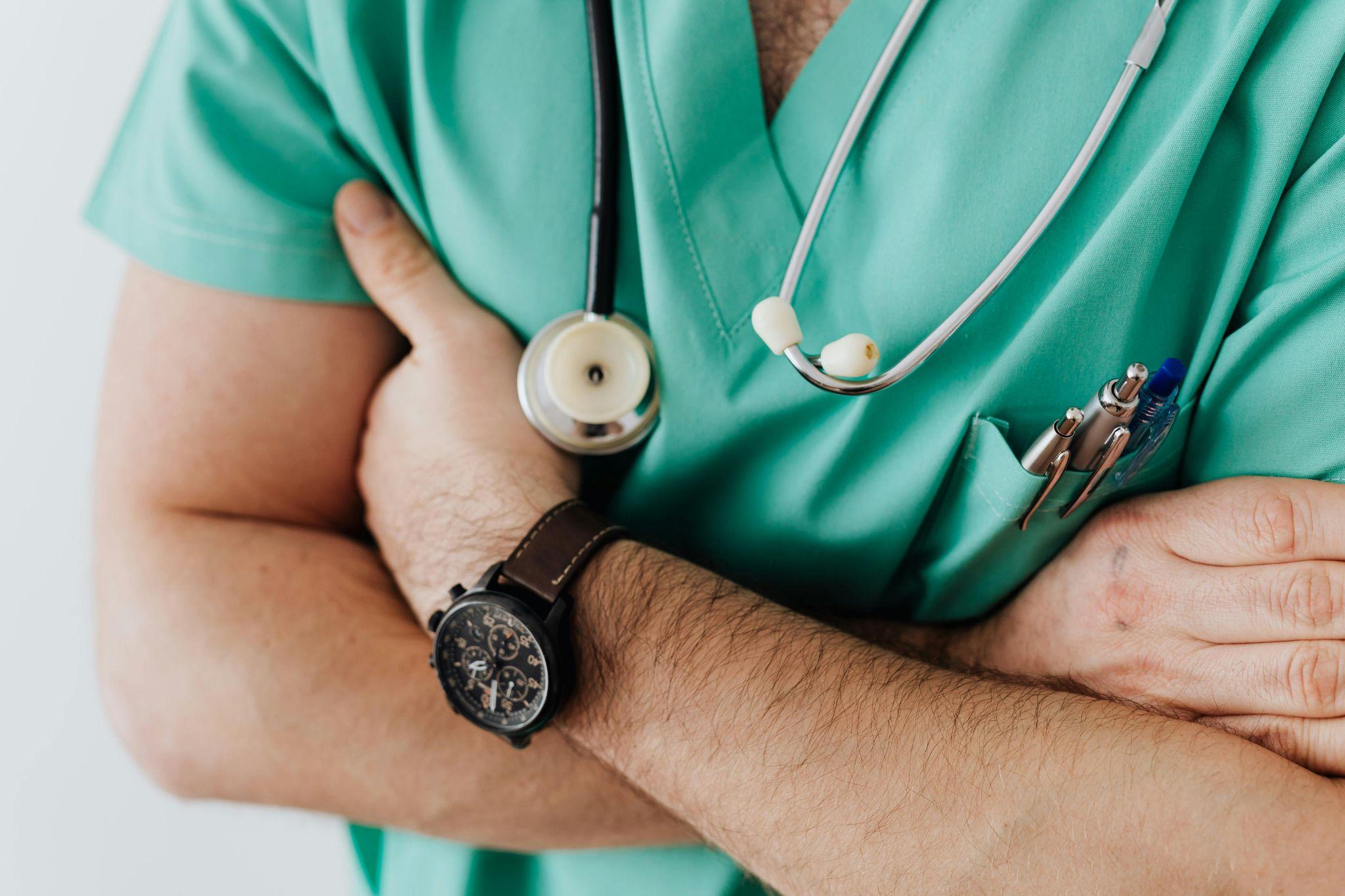 Confident doctor in scrubs with folded arms