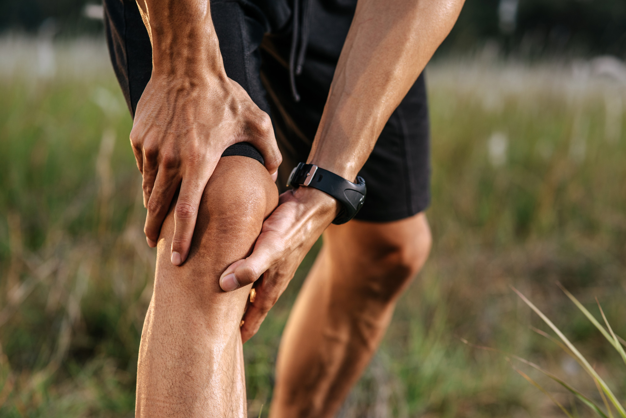 Man holding knee in pain from IT band syndrome