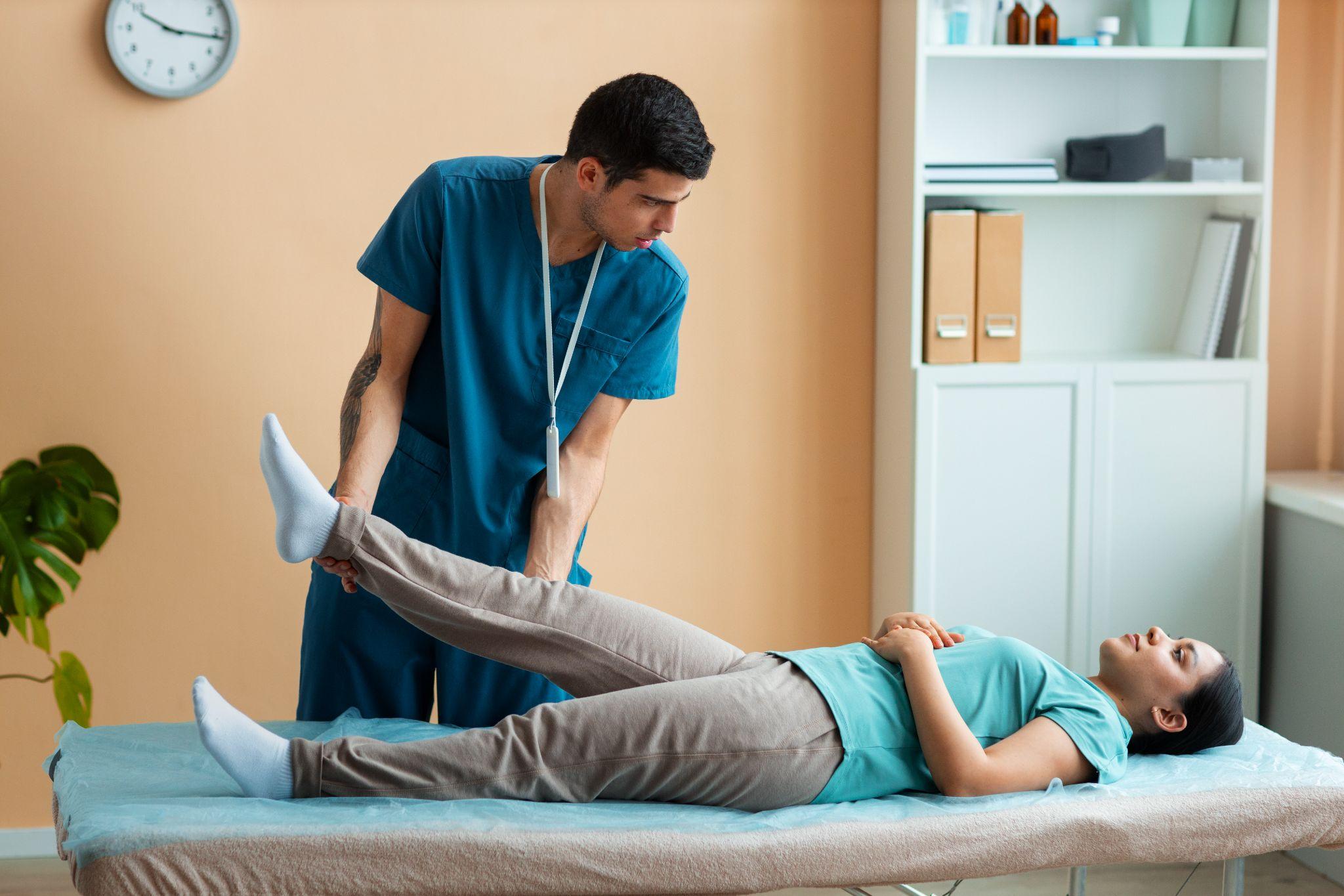 Physical therapist stretching a patient’s leg during sciatica therapy