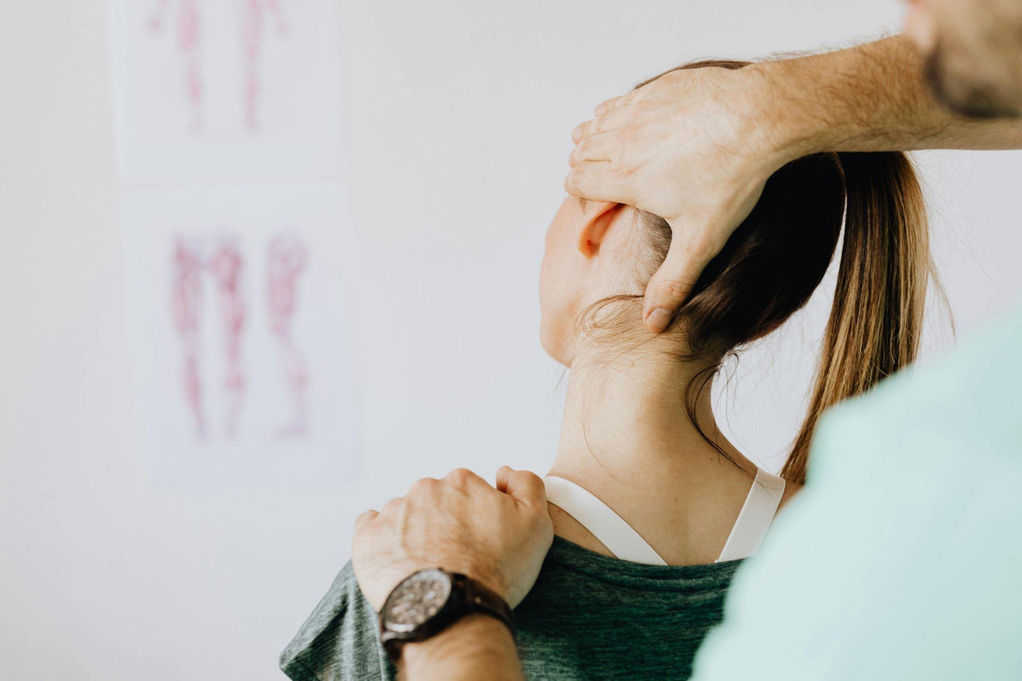 Physical therapist treating neck pain on a female patient