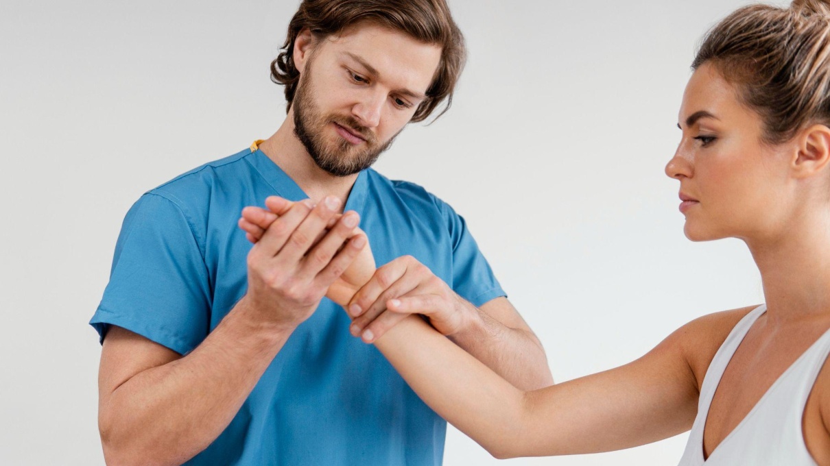 Male physical therapist assisting a female patient with rehabilitation exercises