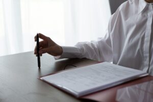 Person holding a pen while reviewing and checking an FMLA form for eligibility.