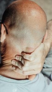 An image of a man holding his neck in pain
