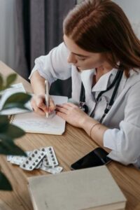 A doctor wearing a lab coat writing a doctor’s note
