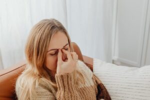 Woman experiencing fatigue and headache while needing a real doctor’s note for work