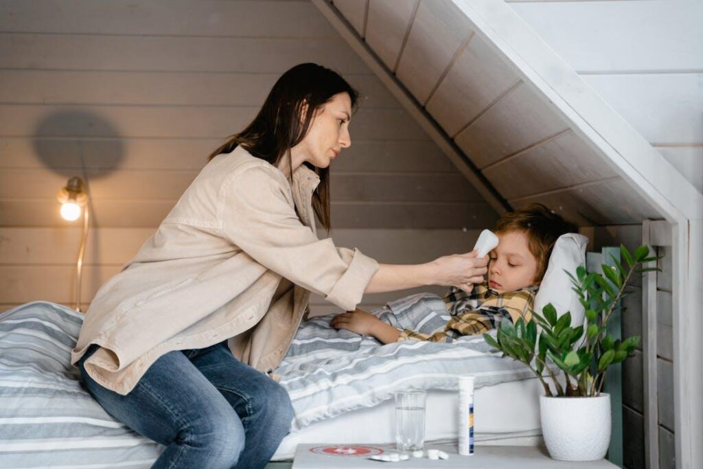 Parent checking child’s temperature at home to monitor fever and night sweats.