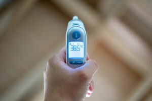 Digital thermometer showing high temperature, possibly requiring a doctor’s note for a leave of absence.