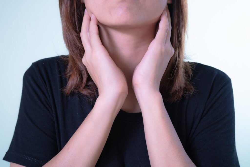 A woman touching her throat due to pain