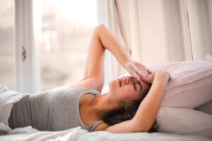Woman resting with a fever while arranging an online doctor’s note