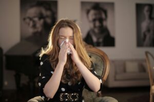 a woman wiping her nose with a tissue