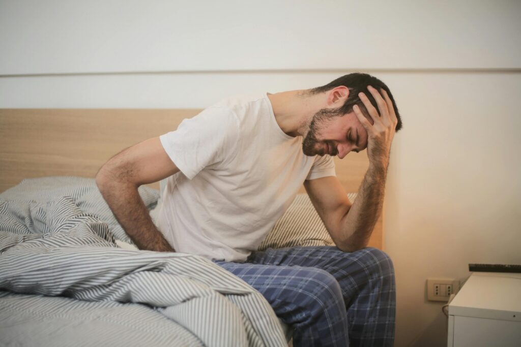 a young man suffering from a headache in the morning