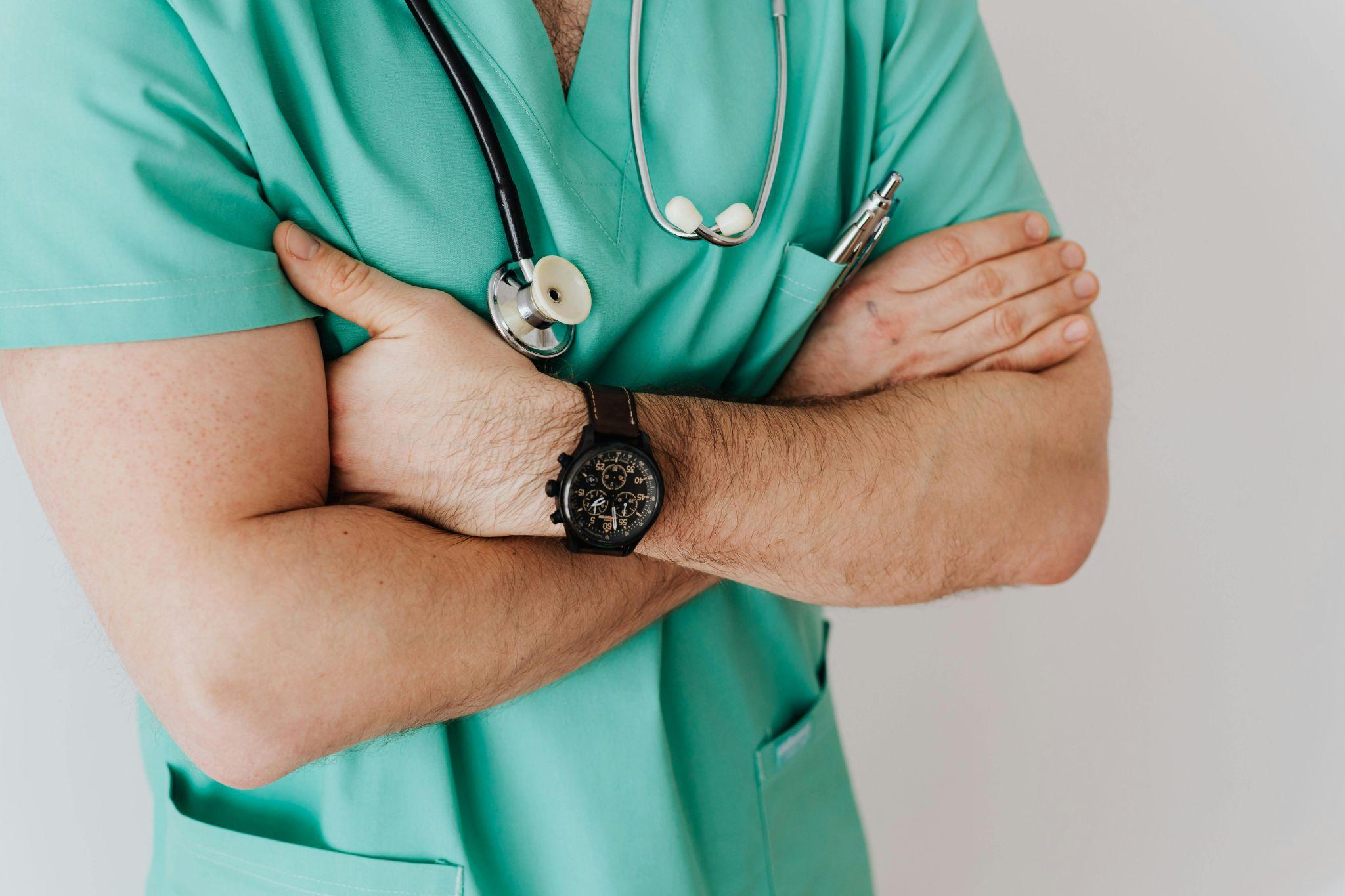 healthcare professional with folded arms holding a stethoscope