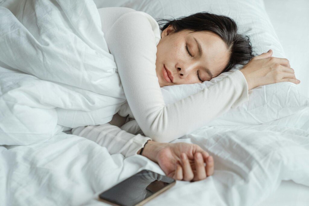 Woman resting peacefully in bed.