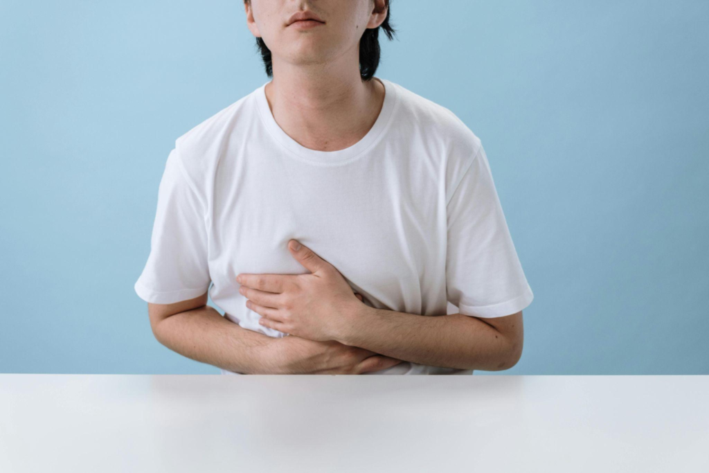 person holding upper abdomen, showing discomfort