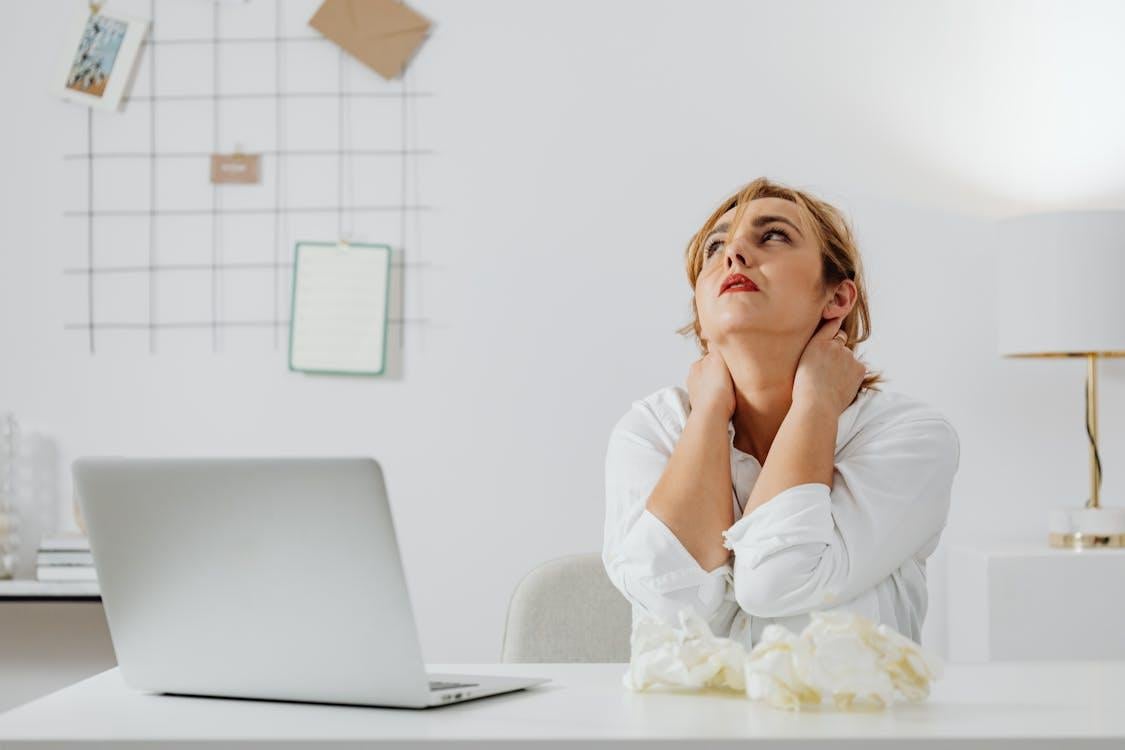 A woman in pain at her desk