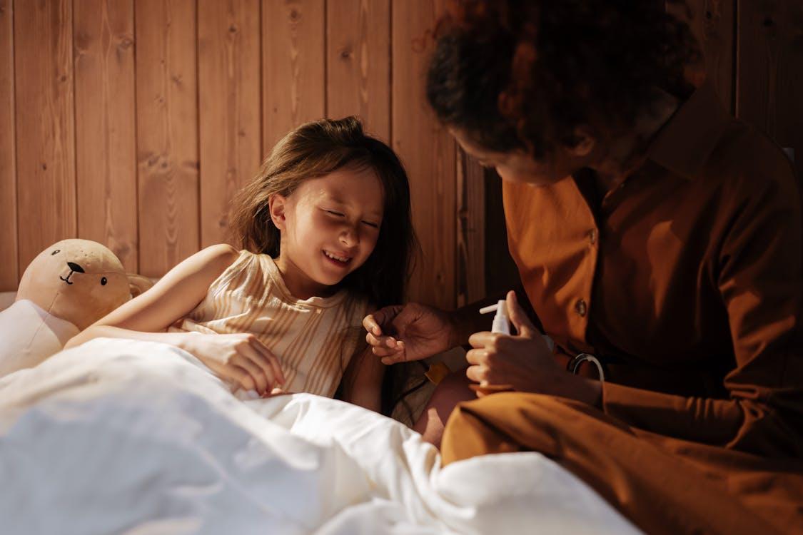 Parent comforting a child in bed during nighttime illness care