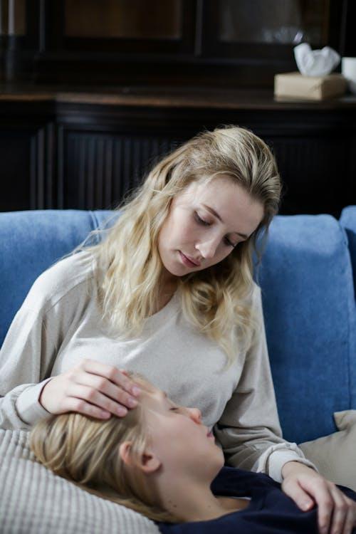 a woman sitting on a couch with her child.