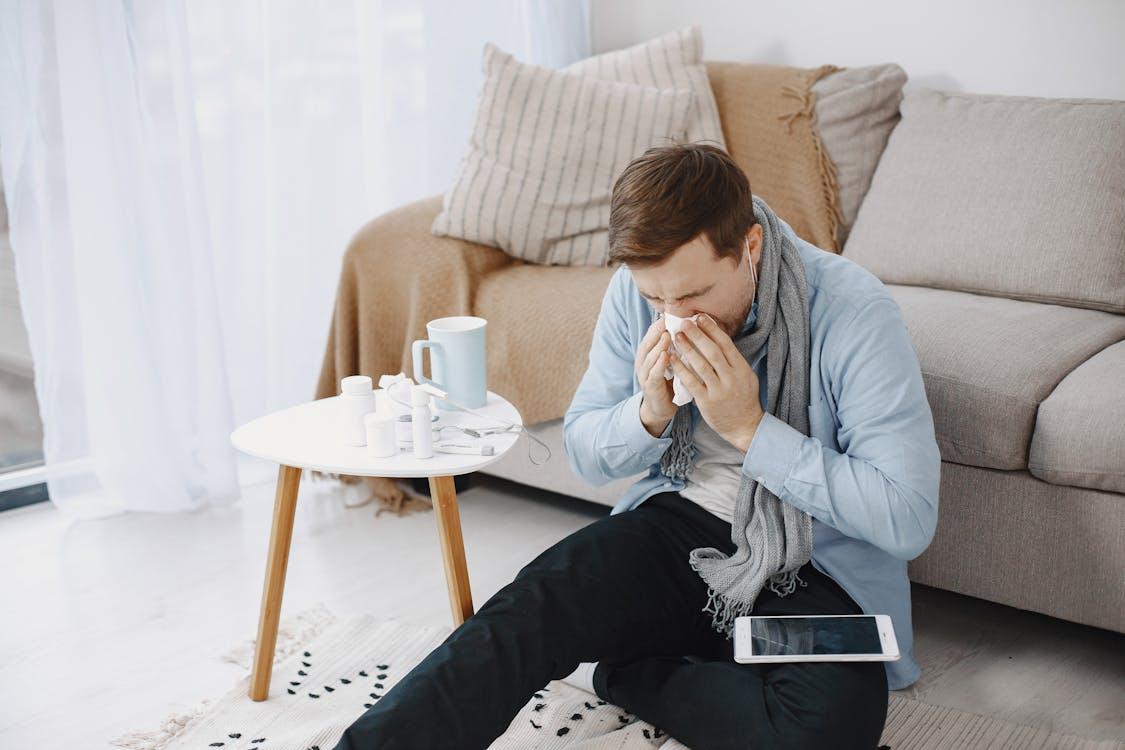Sick man wiping his nose with a tissue