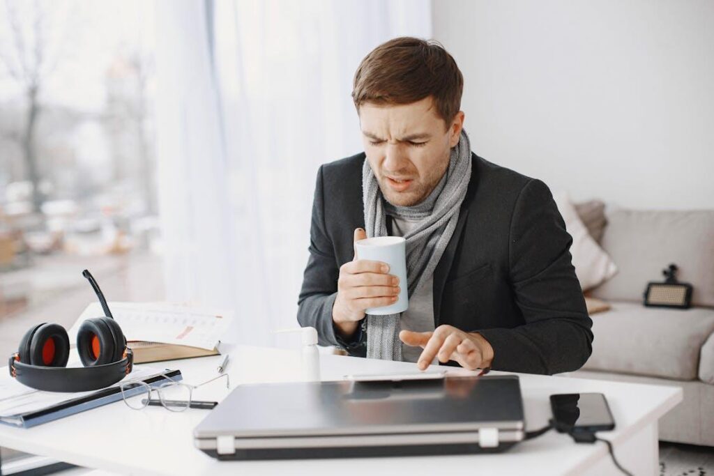 Remote worker feeling sick while using a laptop at home.