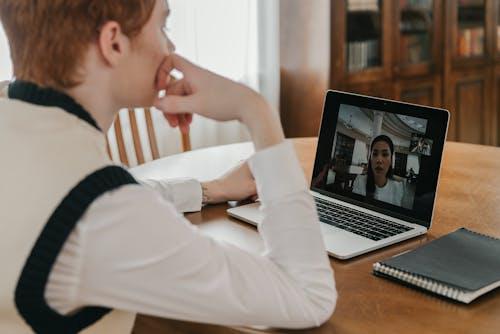 Two people talking through a video call on a laptop